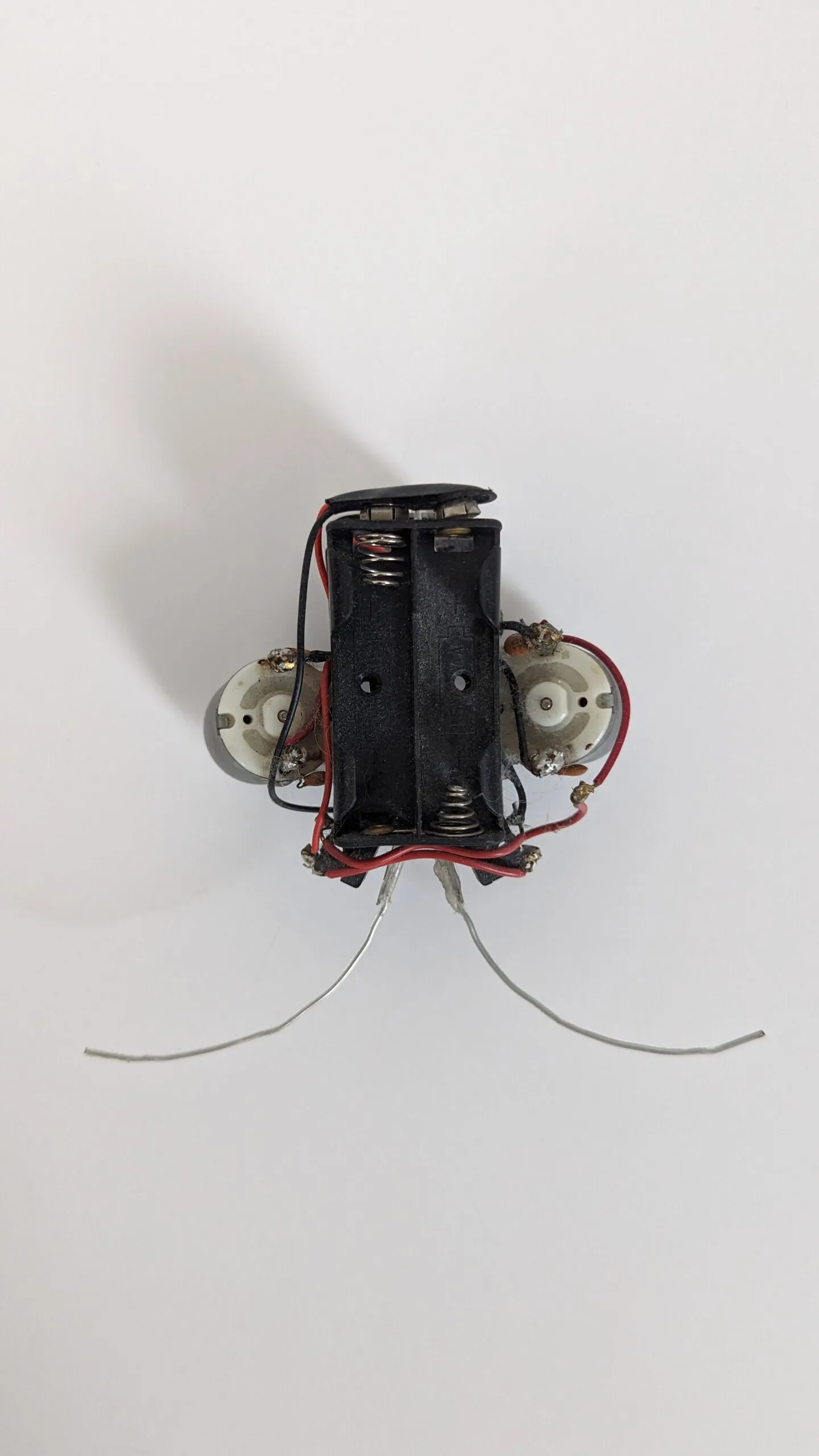 Top view of a Beetle with the empty two-cell battery holder centered between its motors