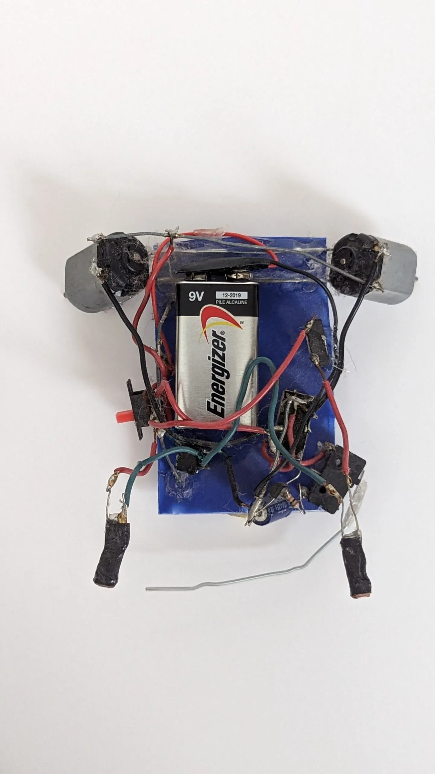 Top-down view of Herbie: the 9V dominates the blue chassis, motors at the far corners