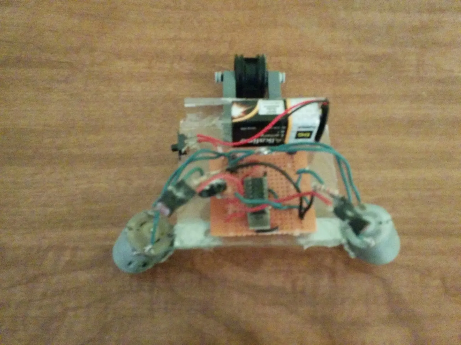 NoBB, older bench photo: protoboard brain and caster nose on a clear plastic chassis, twin motors at the back