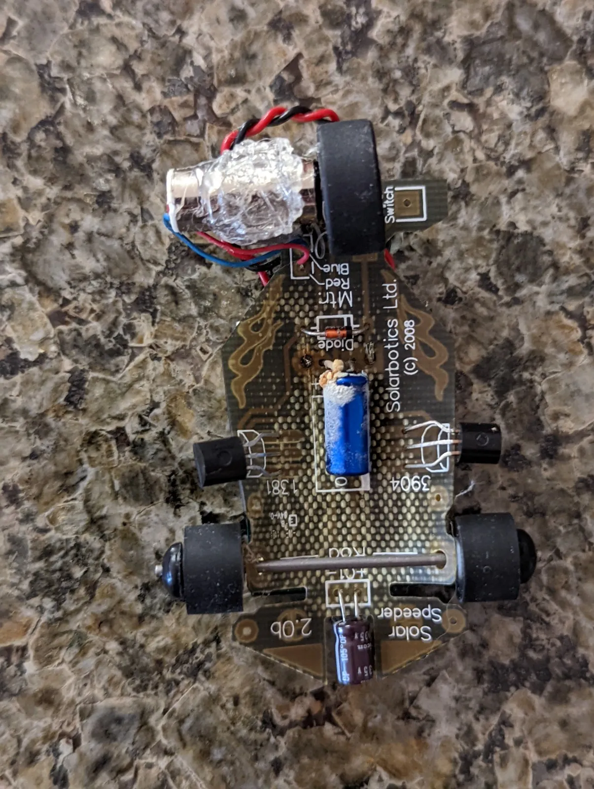 Underside of the Solar Roller's PCB with the blue storage capacitor crusted white where it leaked