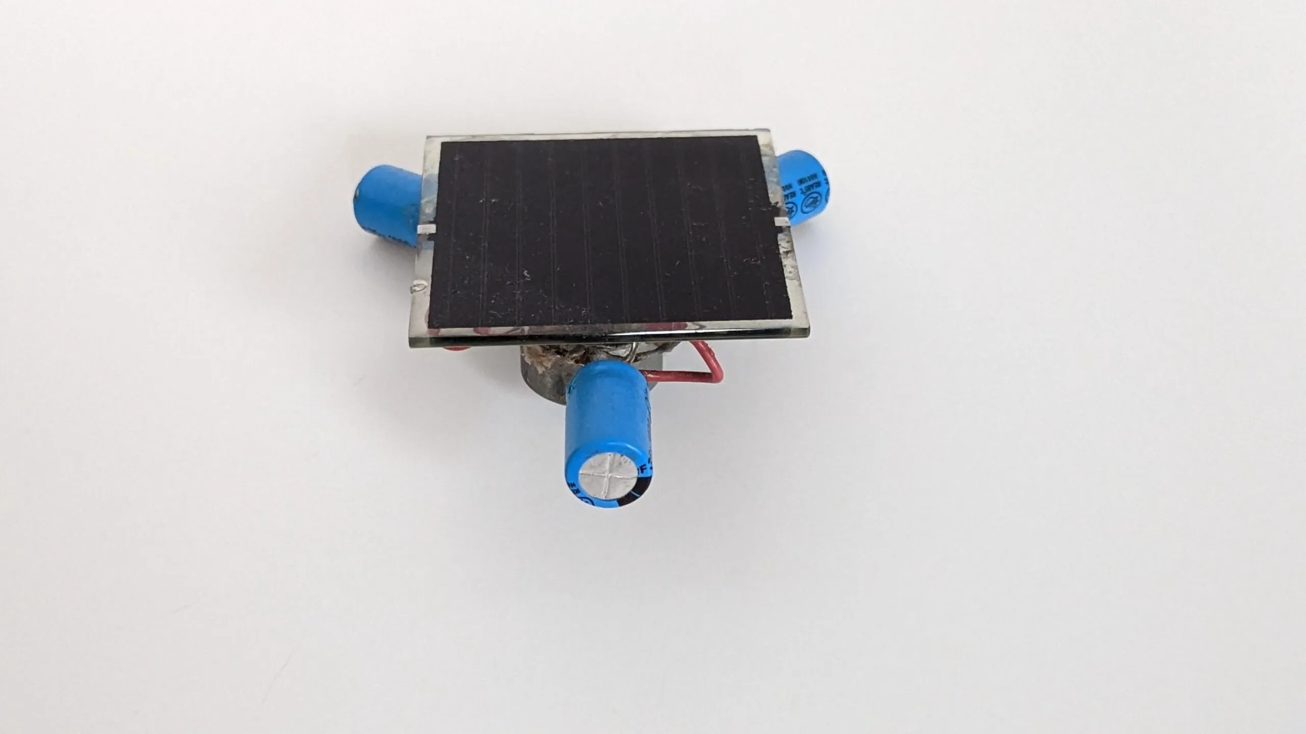 Three-quarter top view of the Symet showing the solar cell and two of its capacitor feet