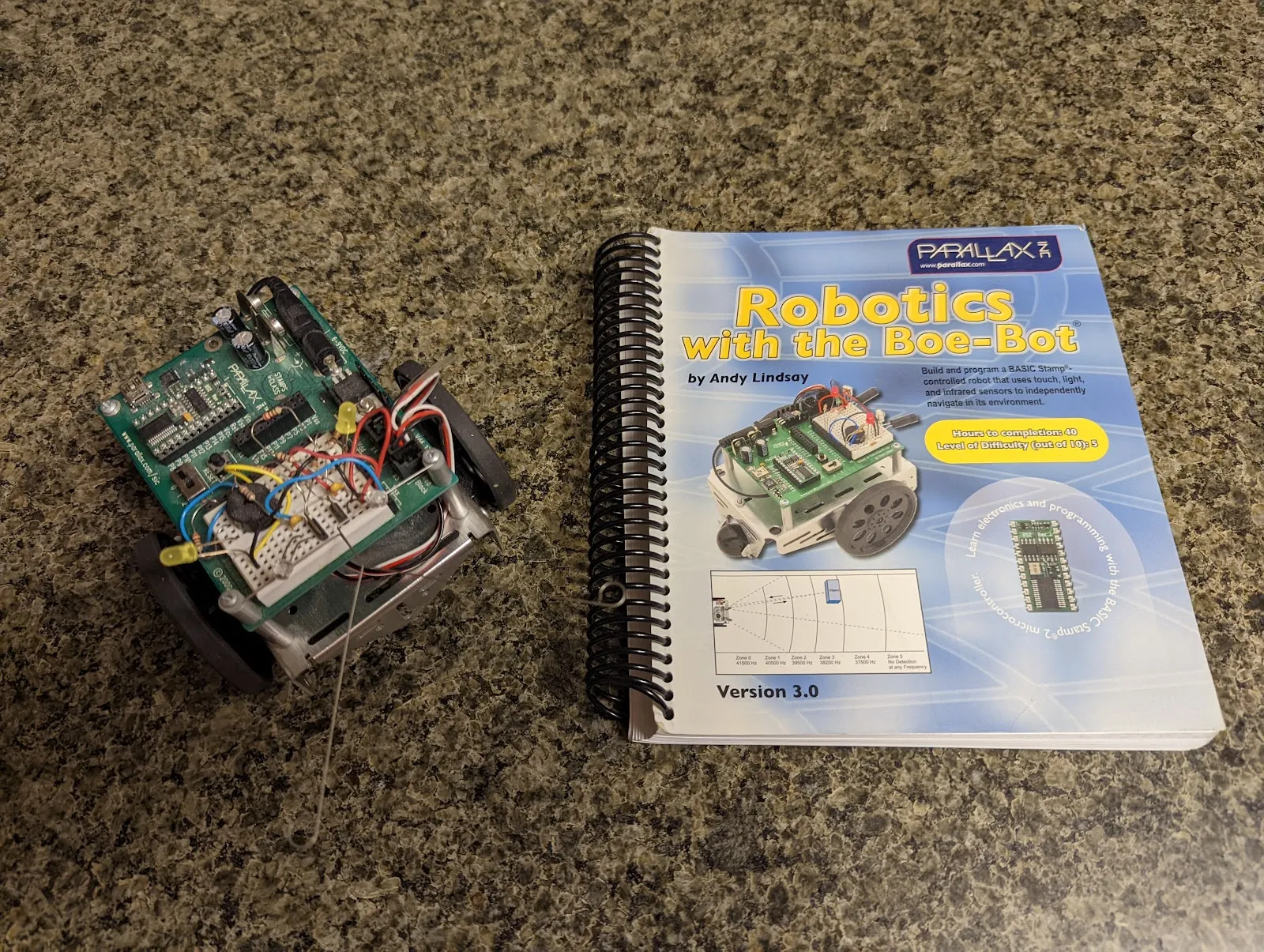 The BOE-Bot beside Andy Lindsay's "Robotics with the Boe-Bot," the book that ran the course