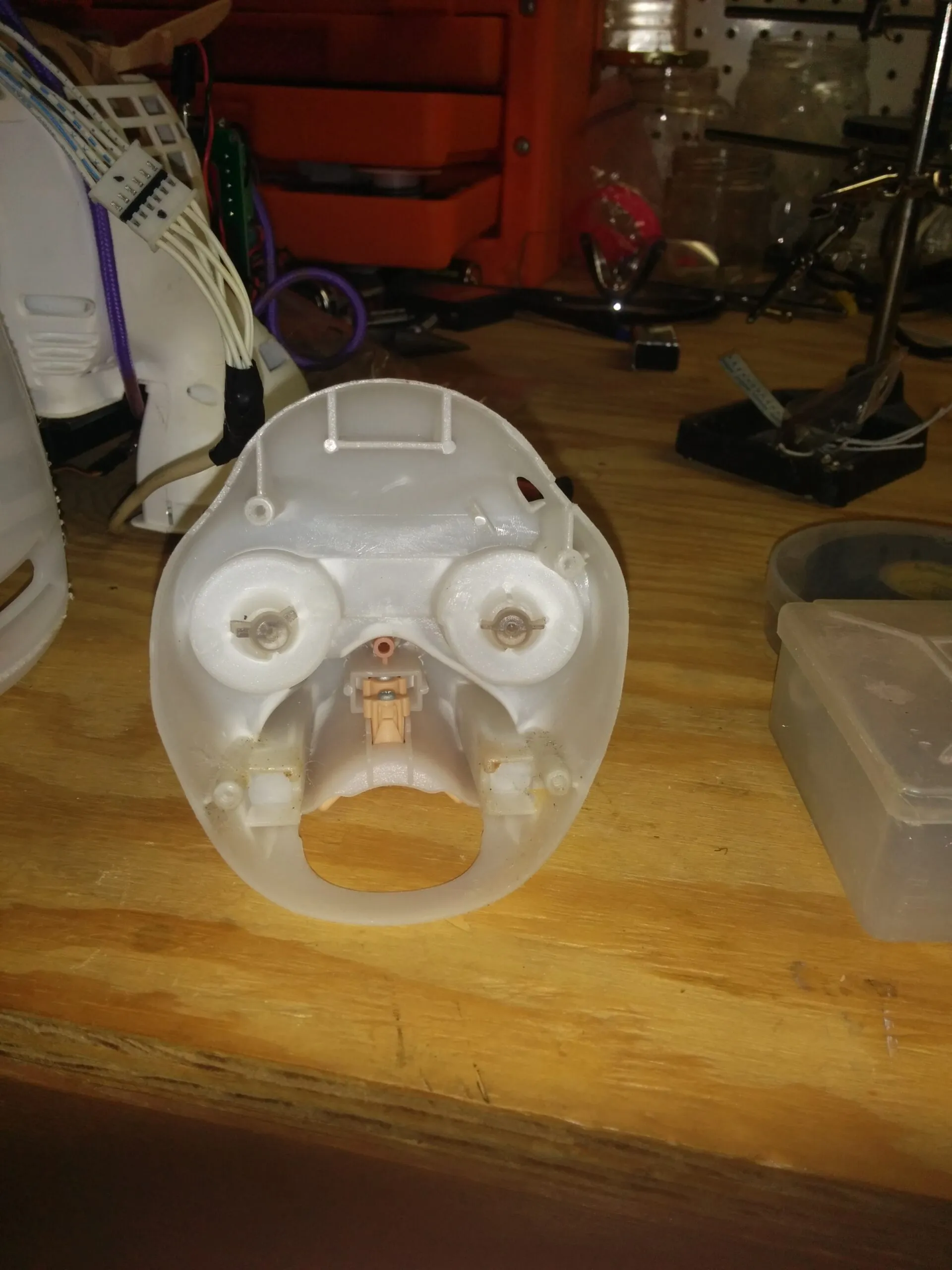 The back side of Bubbles' face shell, eye mechanisms staring back like a little skull