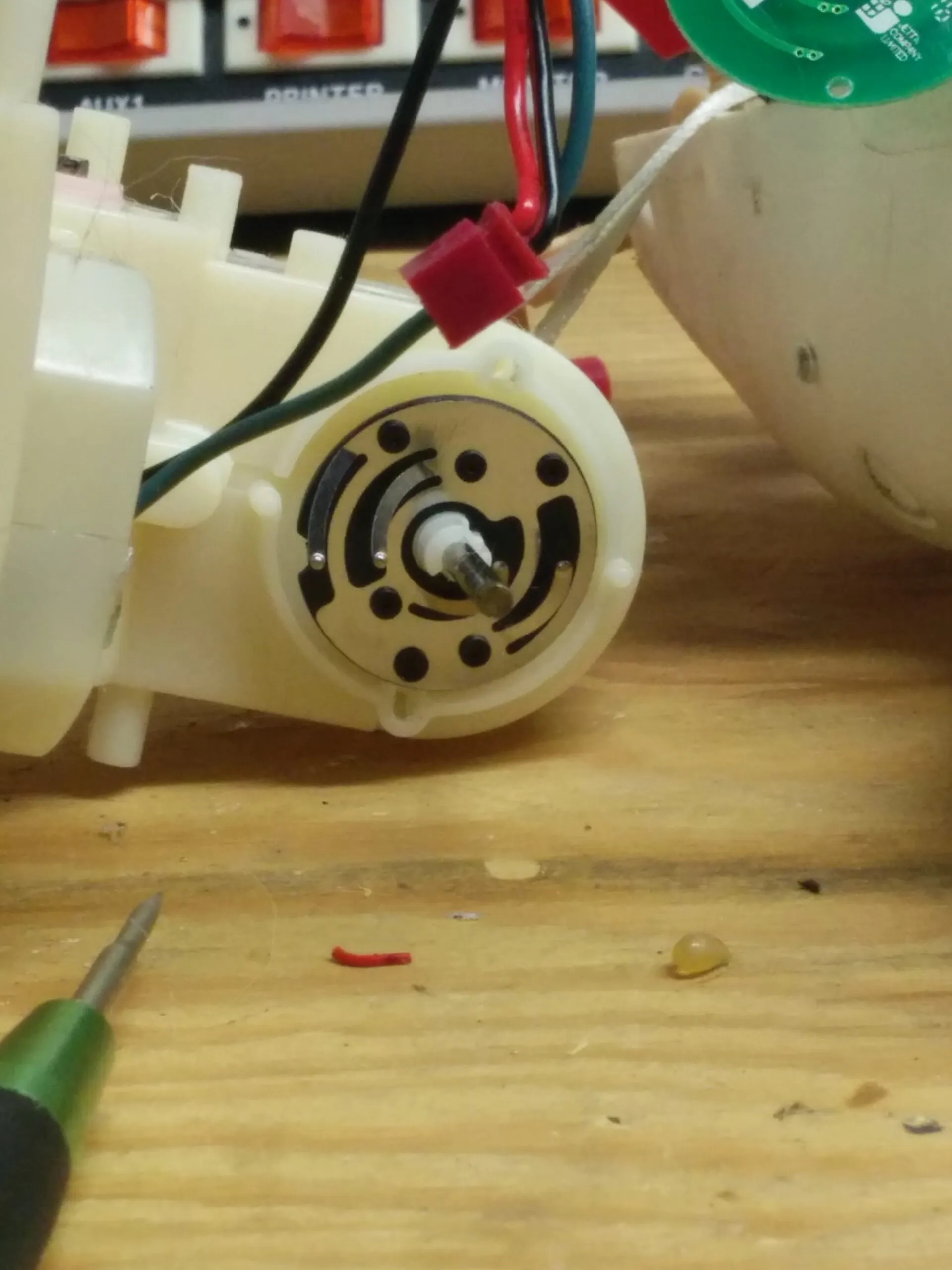 Close-up of a Bubbles gearbox output: a printed contact disc with wiper brushes the toy uses to sense position