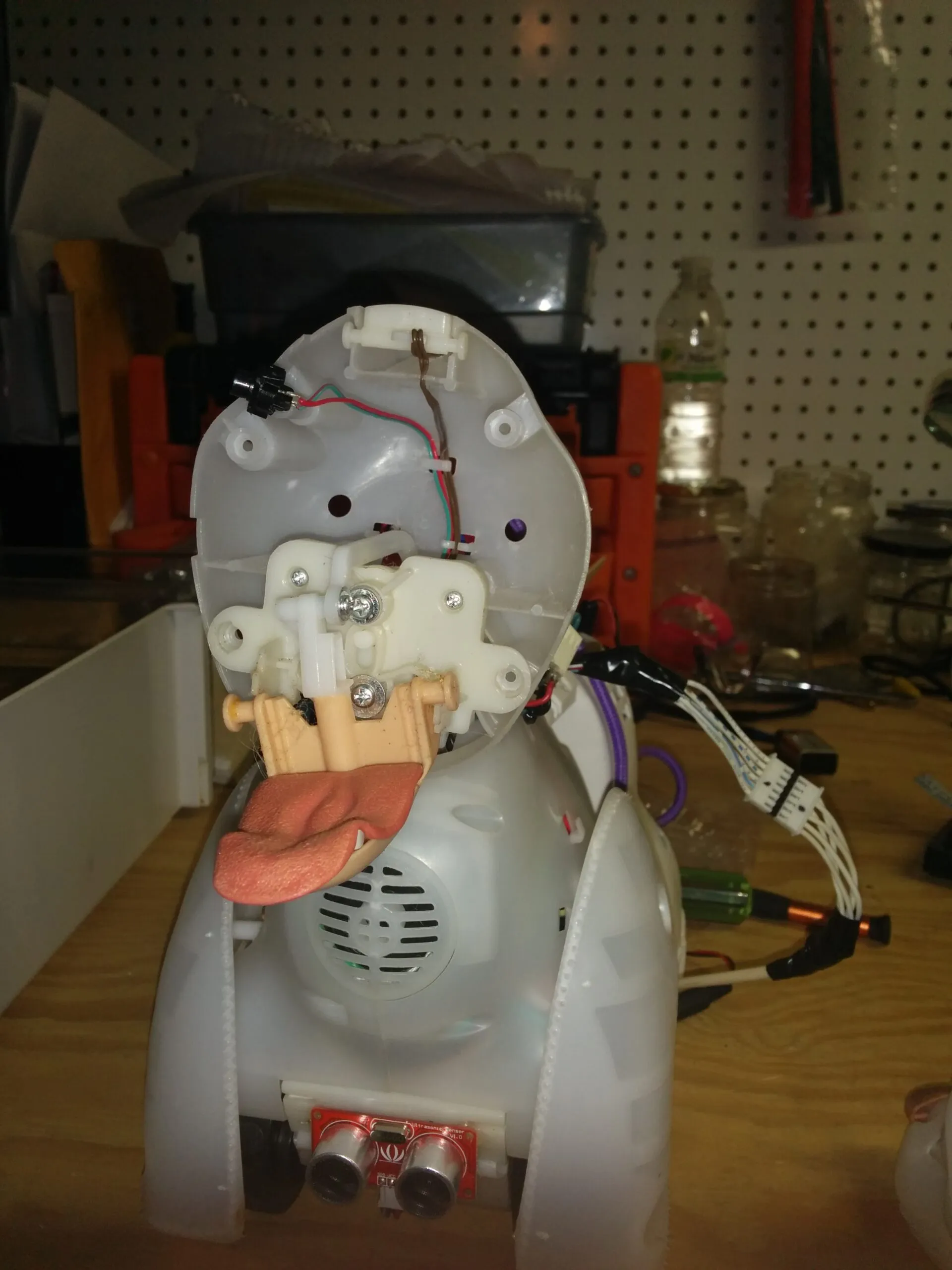 Bubbles' head shell tipped open: tongue linkage, speaker grille, and the ultrasonic sensor in the chest