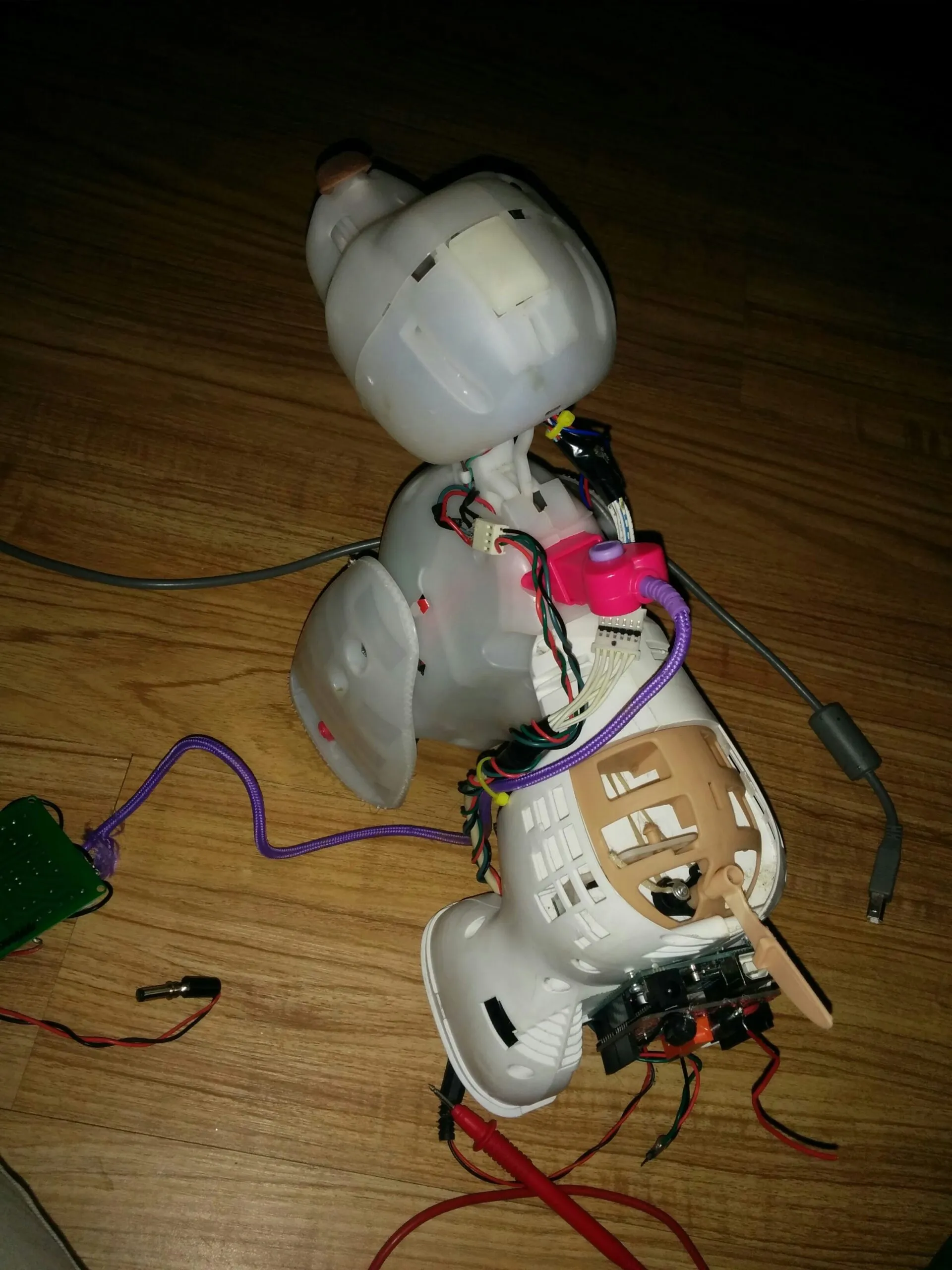 Bubbles mid-teardown on the floor, shells off and multimeter leads already out
