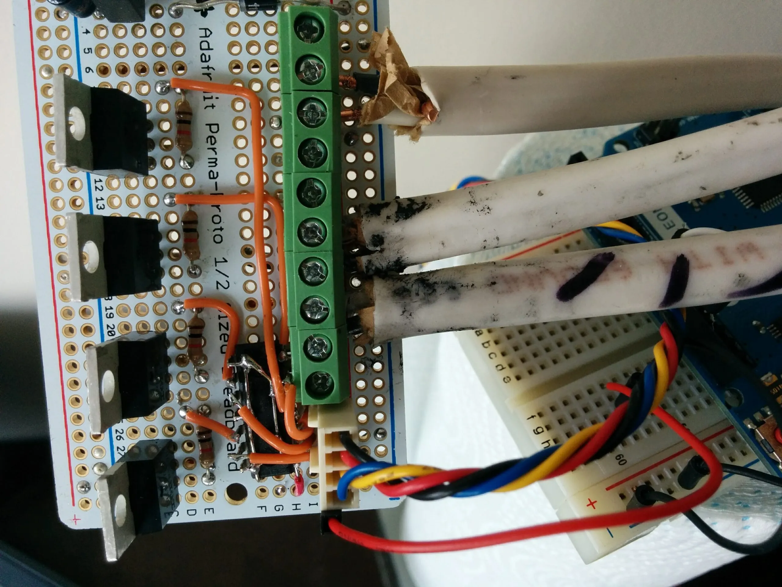 The strip driver: MOSFETs on an Adafruit Perma-Proto, screw terminals fanning out to the ceiling runs