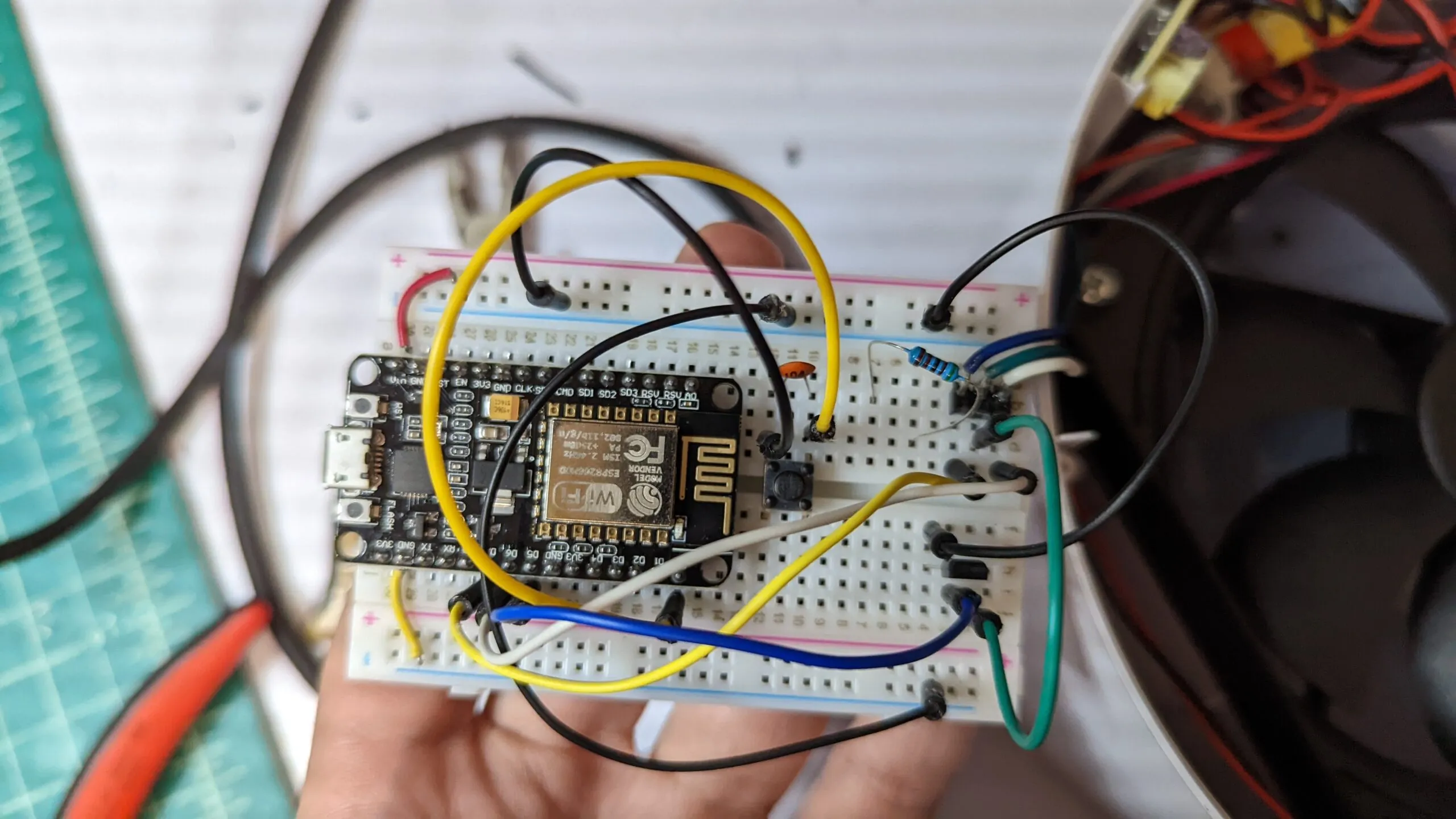 The NodeMCU breadboard in hand, the MOSFET and a resistor beside it, jumper spaghetti fanned out into the filter's harness