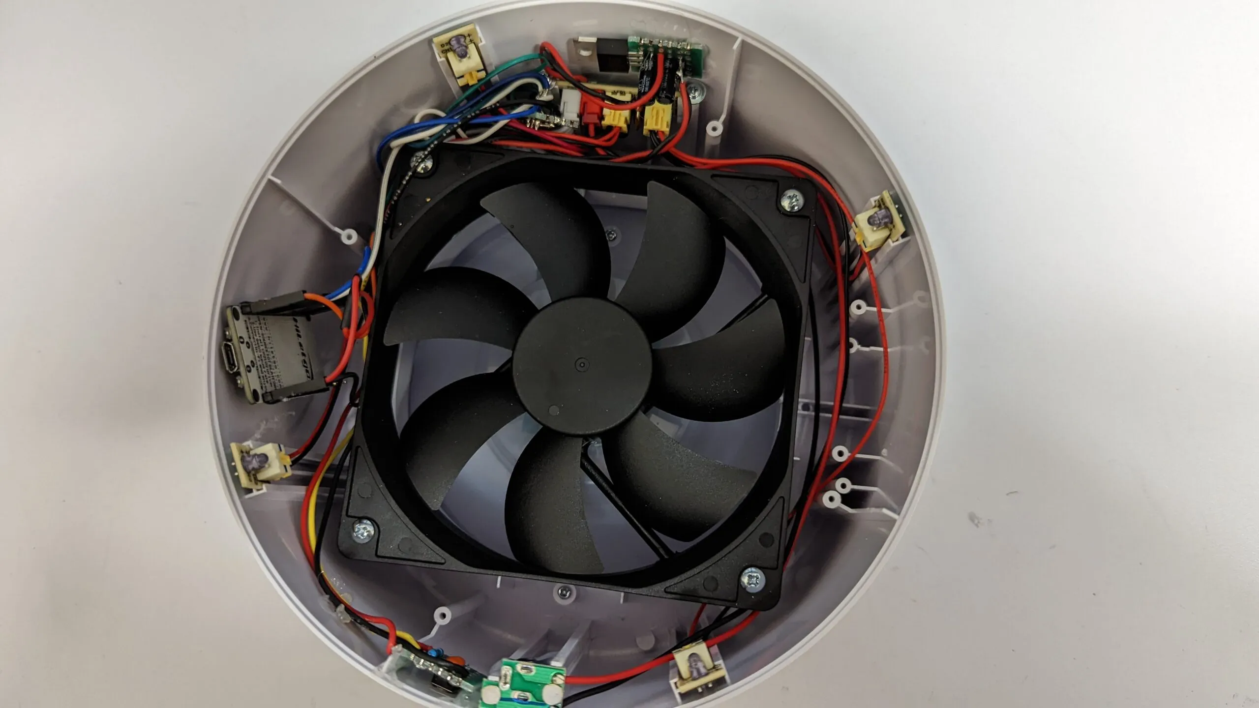 The tidied final assembly: fan centered, NodeMCU flat against the shell wall, boards screwed into their bays