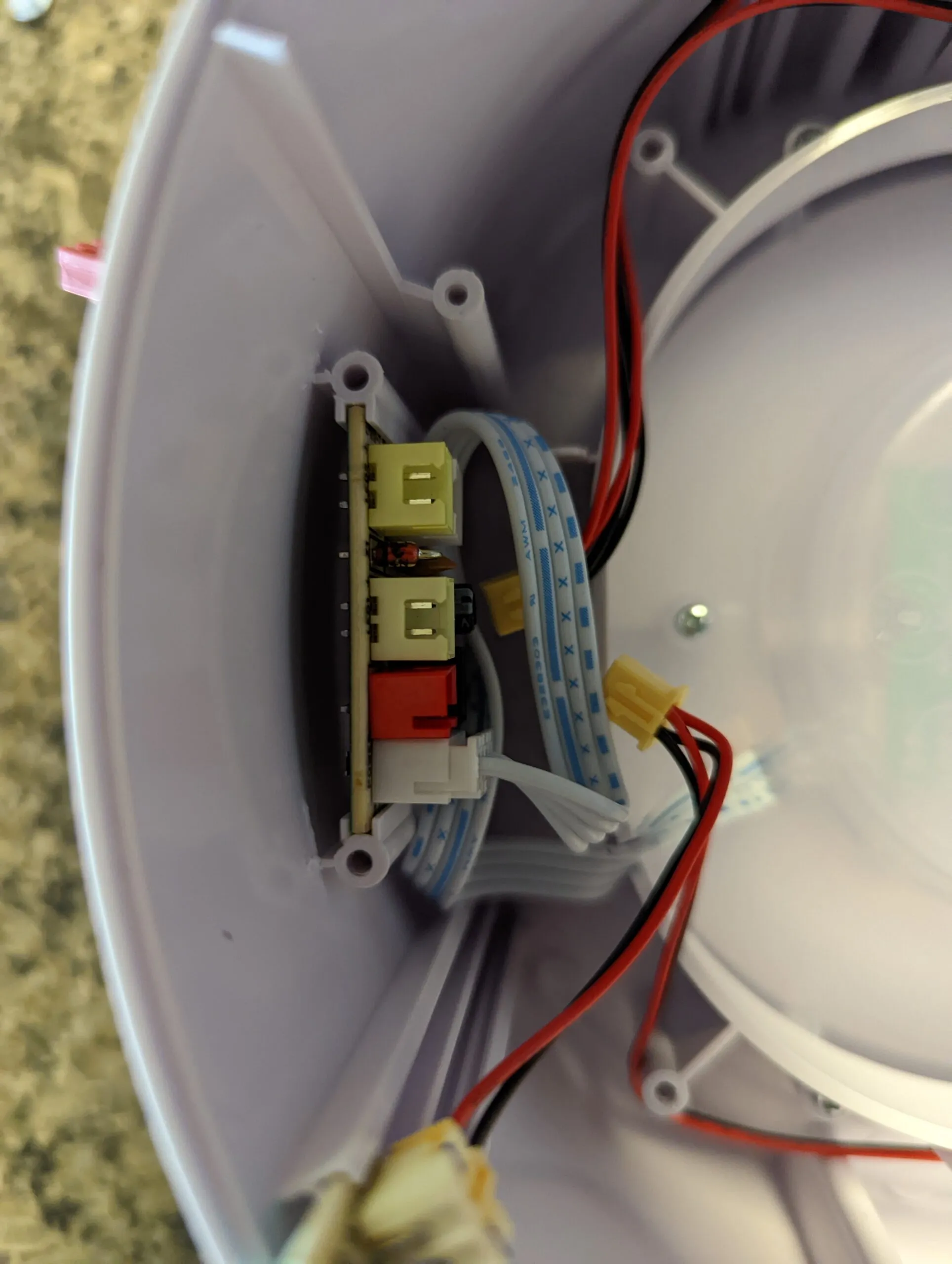 Same board with the fan out of the way: the LED ring plug pulled too, and the flat ribbon that runs up to the control dome