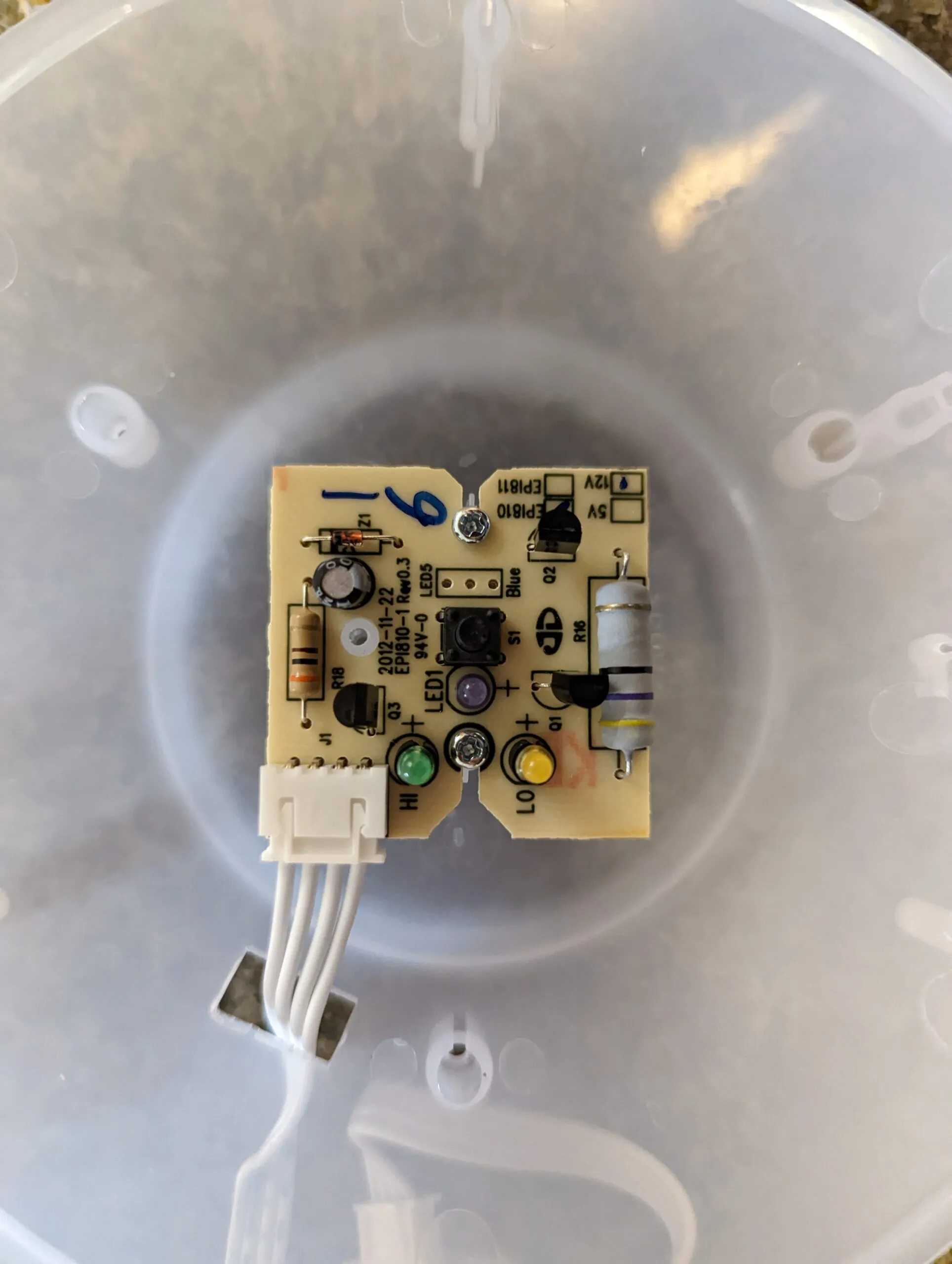 The EPI810 control board inside the dome: the mode button in the middle, green HI and yellow LO LEDs below it, and 12 V / 5 V select pads in the corner