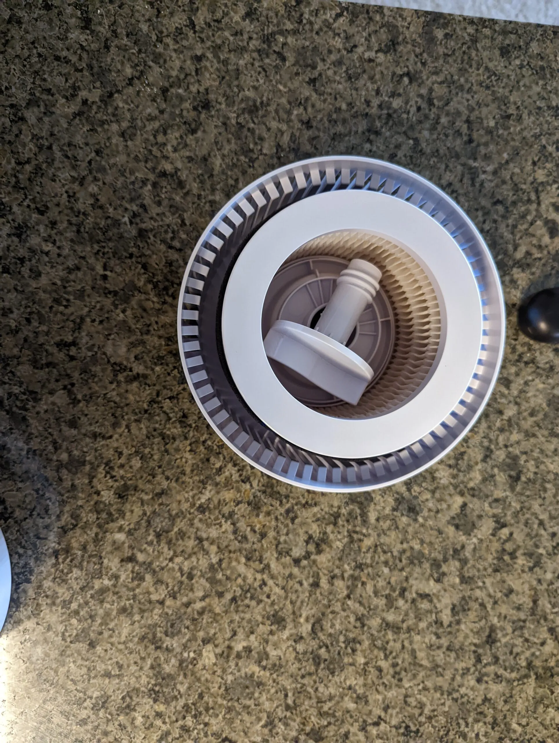 Looking down into the Koios with the lid off: the HEPA cartridge sitting in the base, the gray plastic screw knob on top holding it in