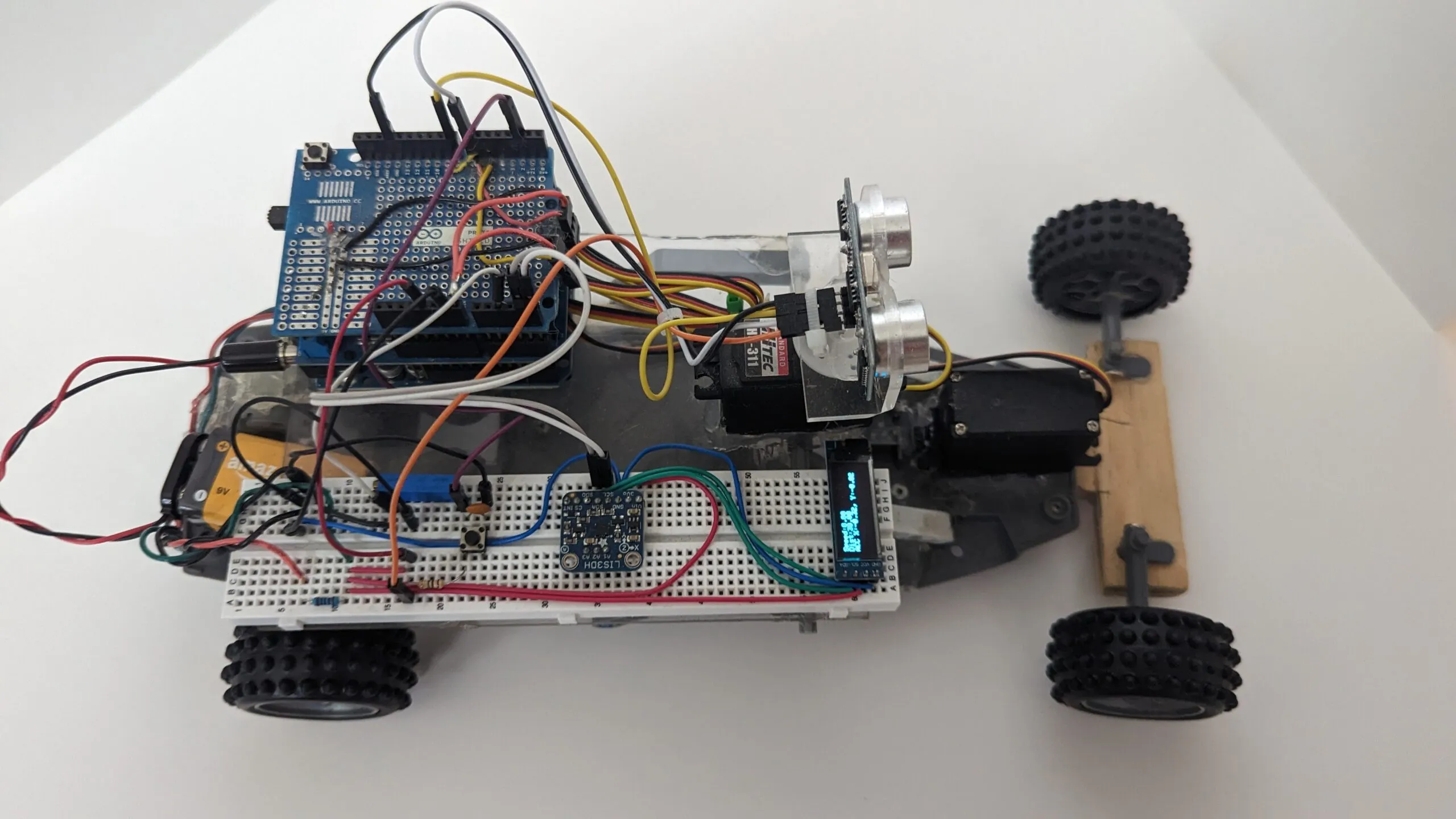 RoverBot from above: protoshield stack, breadboard, OLED readout, and the head servo with its ultrasonic mast