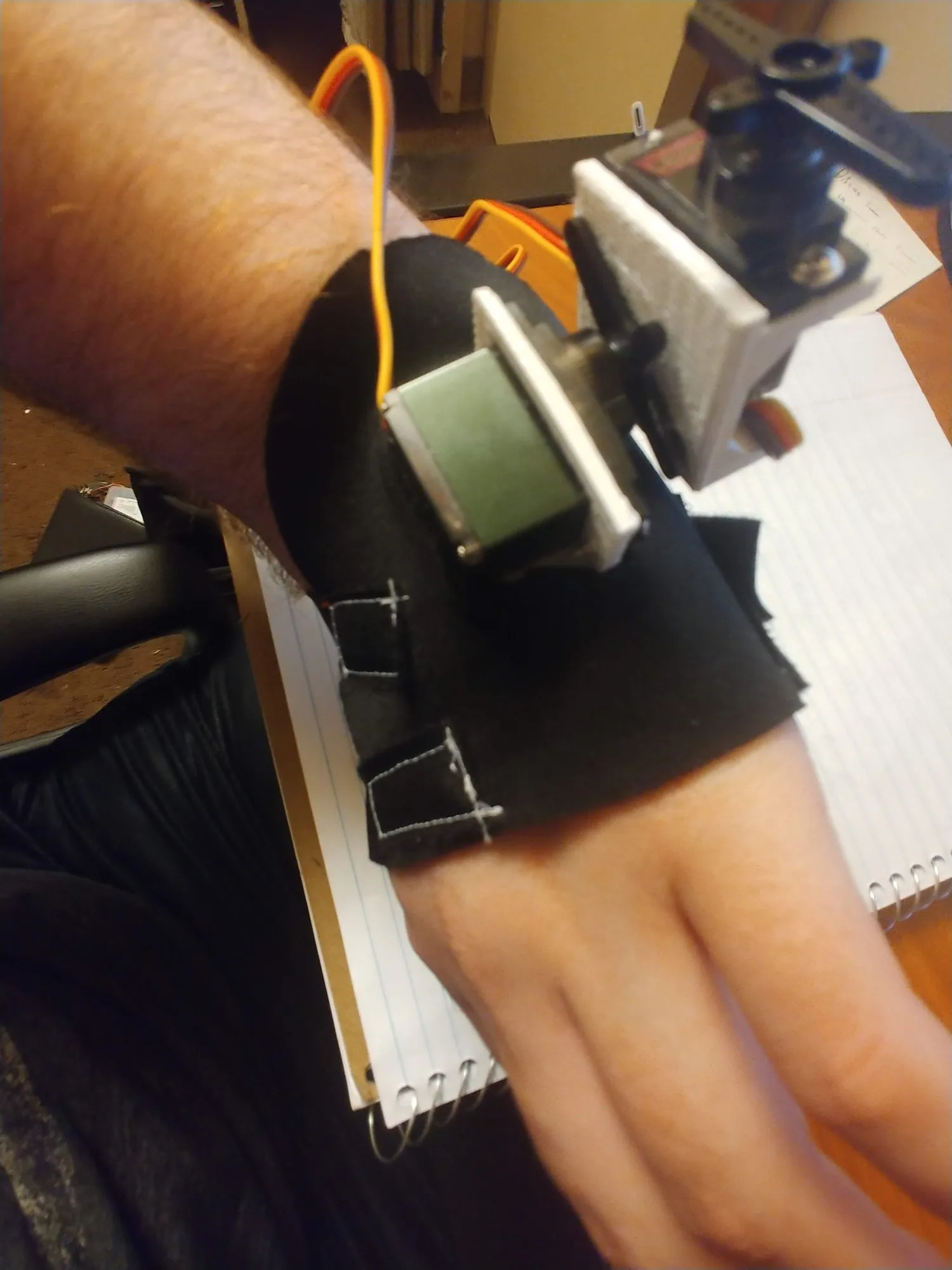 The neoprene brace on the left hand with a servo strapped at the wrist, April 2019.